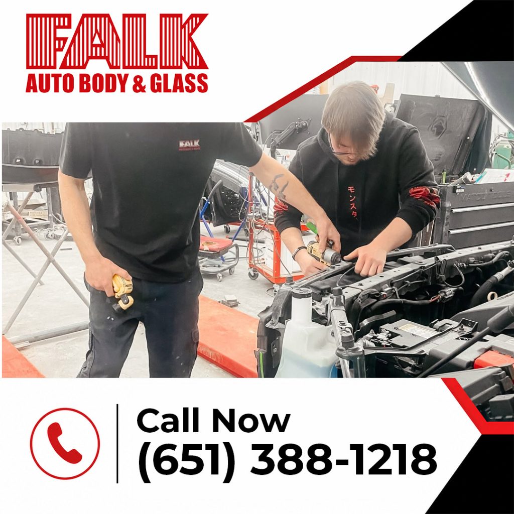 Promotional graphic from Falk Auto Body & Glass showing two auto mechanics working inside an active vehicle engine bay.